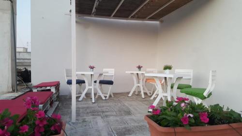 莱韦拉诺B&B la Coccinella的一间设有白色桌椅和鲜花的客房