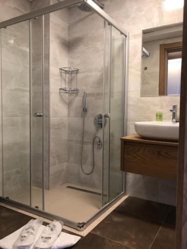 阿拉恰特Neva Hotel Alaçatı的一间带玻璃淋浴间和水槽的浴室