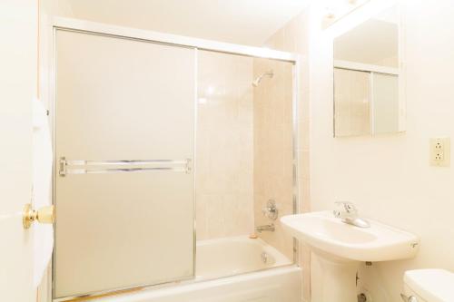 温哥华英湾酒店的带淋浴和盥洗盆的白色浴室