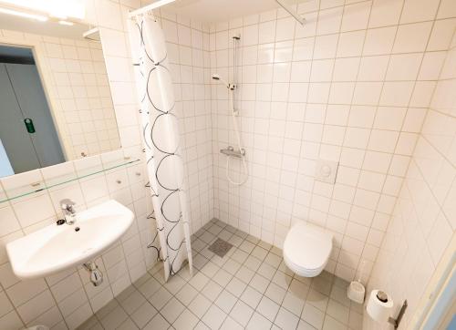 卡伯尔沃格Lofoten sommerhotell og vandrerhjem的带淋浴、盥洗盆和卫生间的浴室