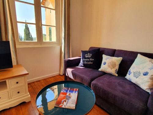 新堡Apartment Picasso in großem Park mit geheiztem Pool的客厅配有紫色沙发和玻璃桌
