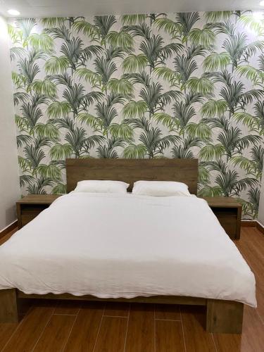 拉斯阿尔卡麦The Hide的一间卧室配有一张带壁纸的大床