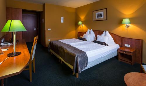 塔塔Hotel Gottwald的酒店客房设有一张大床和一张书桌。