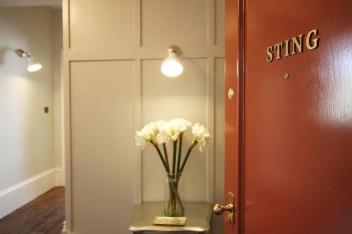 斯坦福德Old Bank Apartments的门边桌子上一个花瓶