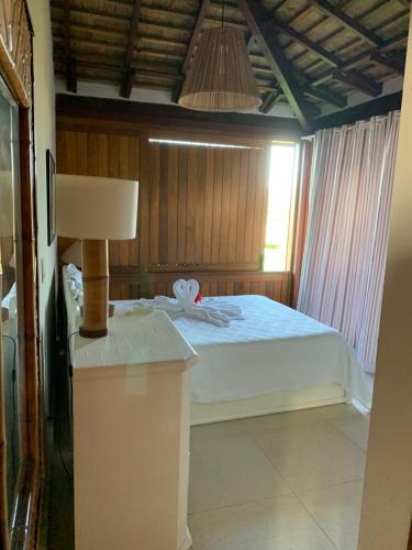 普拉亚多Casa das Acácias的一间卧室配有一张床和一张带台灯的桌子