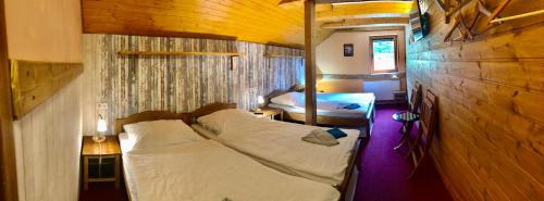 科热诺夫卡碧坦卡旅馆的木制客房内的一间卧室配有两张床
