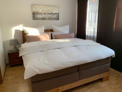 柯尼希施泰因易北Luxuriöse Stadtwohnungen in Königstein的卧室内的一张带白色床单和枕头的床