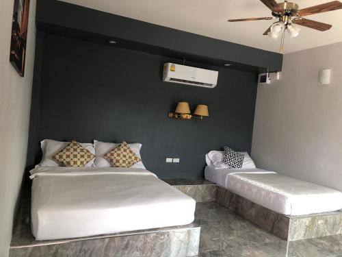 北榄坡Relax Resort的一张黑墙客房内的两张床