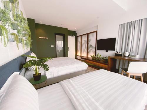 哥打京那巴鲁The Atelier Boutique Hotel的酒店客房设有两张床和一台平面电视。