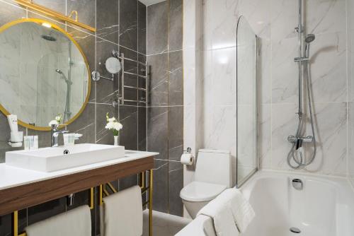敖德萨敖德萨OK酒店的浴室配有盥洗盆、卫生间和浴缸。