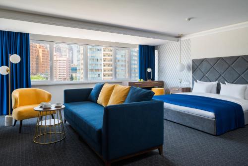 敖德萨敖德萨OK酒店的酒店客房配有蓝色的沙发和床。