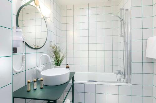 索恩河畔沙隆圣雷吉斯酒店的一间带水槽、浴缸和镜子的浴室