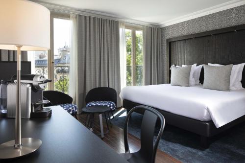 巴黎香榭丽舍雷格西亚酒店的酒店客房带一张床、一张桌子和椅子
