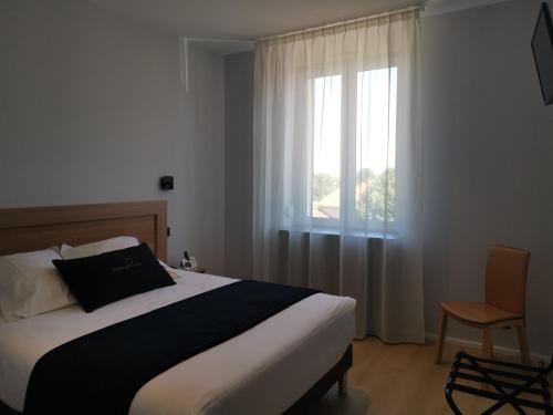 Chazelles-sur-Lyon布兰查德城堡酒店的一间卧室配有一张带窗户和椅子的床