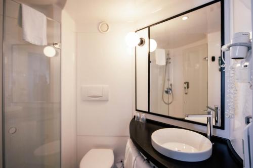 卡斯特尔德费尔斯巴塞罗那卡斯特尔德菲尔宜必思酒店的一间带水槽和镜子的浴室