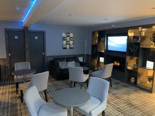 弗雷泽堡达夫隆酒店的客厅配有桌椅和电视
