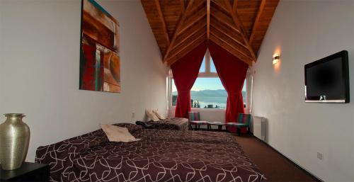 圣卡洛斯-德巴里洛切科尔顿酒店的一间卧室设有一张床和一个大窗户