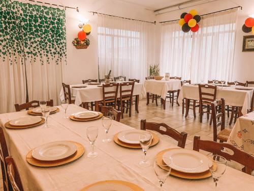 加利亚诺德尔卡波Agriturismo Baccole的用餐室配有桌椅、盘子和酒杯