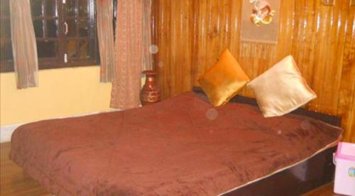 甘托克Tip Top Gujarati House的卧室内的一张带两个枕头的床