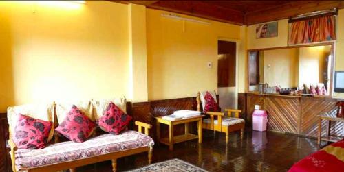 甘托克Tip Top Gujarati House的客厅配有沙发和桌子