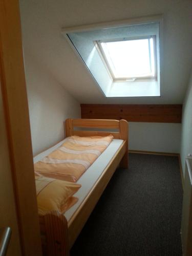 SchönebergFerienhof am Nationalpark的一间小卧室,配有一张带天窗的床