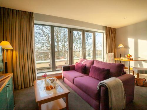 戈尔韦康诺特酒店的客厅配有紫色沙发和窗户