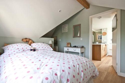 莱姆里吉斯Bentley Rise的一间卧室配有一张带粉红色波卡圆点床单的床。