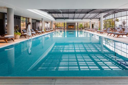 罗什平纳Mizpe Hayamim by Isrotel Exclusive的大楼内带桌椅的大型游泳池