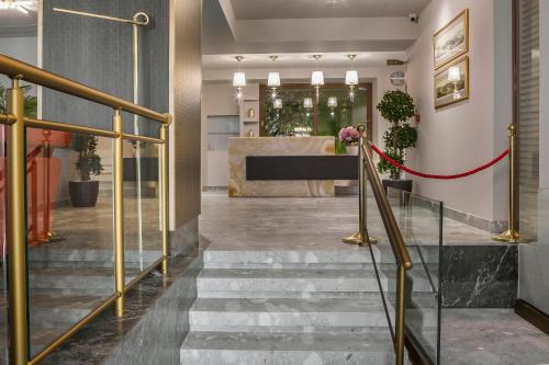 雅典Royalty Hotel Athens的设有一个设有楼梯的大堂和一个前台