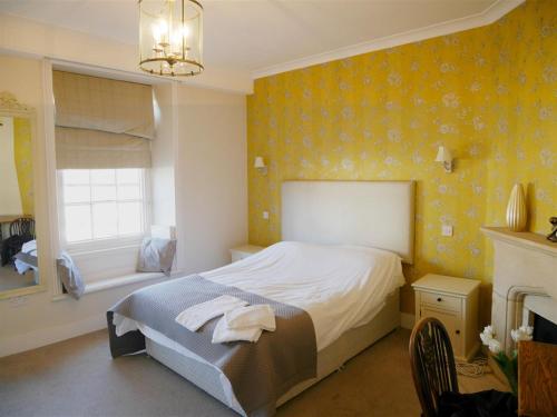 Highworth萨罗森海德宾馆的卧室配有床、壁炉和窗户。