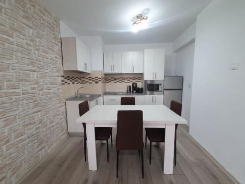 阿尔杰什河畔库尔泰亚Apartament Posada的白色的厨房配有白色的桌子和椅子