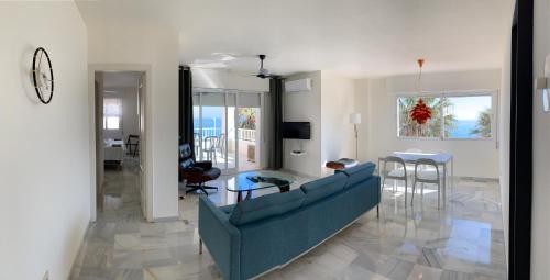 内尔哈Fuentes de Nerja的客厅配有蓝色的沙发和桌子