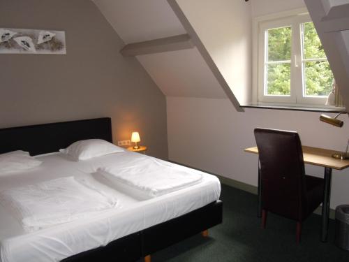 梅赫伦迈卡特酒店的一间卧室配有一张床、一张书桌和一个窗户。