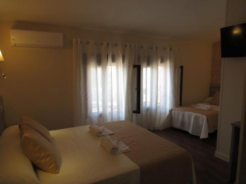 贝拉新镇Albergue El Encuentro的酒店客房设有两张床和窗户。