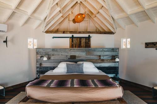 霍普金斯Thatch Caye Resort a Muy'Ono Resort的一张位于带木制天花板的客房内的大床