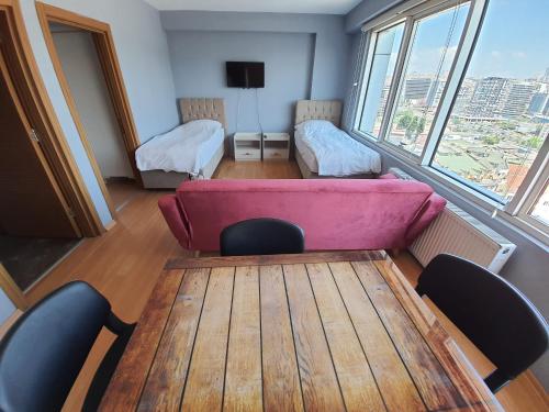 伊斯坦布尔学术公寓的配有粉红色的沙发、桌子和椅子的房间