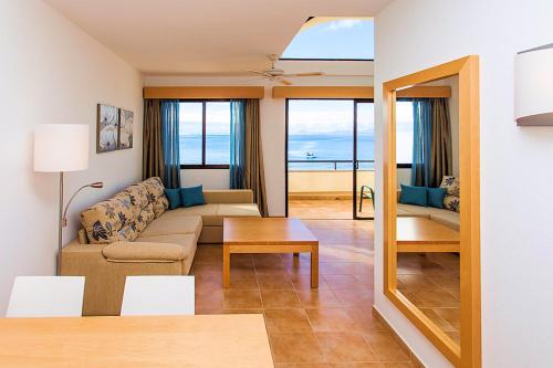 普拉亚布兰卡皇家莫妮卡SBH酒店的客厅配有沙发和桌子
