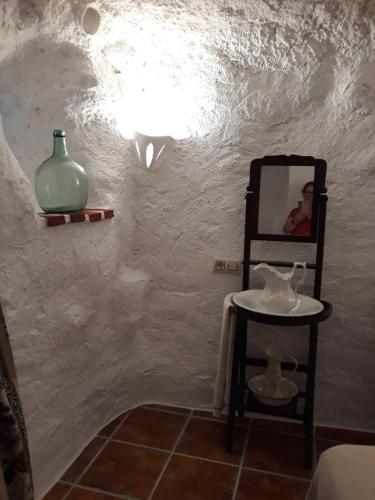 Pegalajar少斯乡村民宿的浴室设有镜子、桌子和花瓶