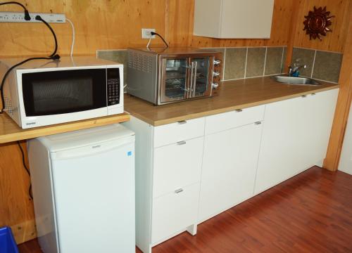 Inn at the Cape的厨房配有白色橱柜和台面上的微波炉