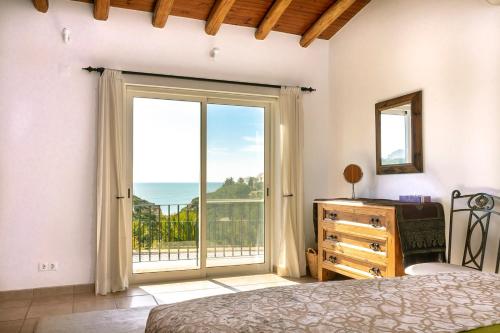 贝纳吉Villa Diane Luxury Cottage Ocean views pool的一间卧室设有一张床和一个美景窗户。
