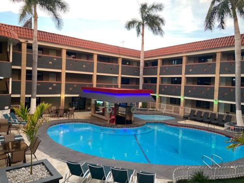 埃莫西约Hotel La Finca的棕榈树酒店前的游泳池