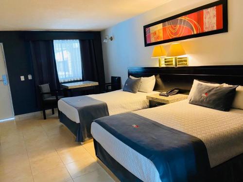 埃莫西约Hotel La Finca的酒店客房配有两张床和一张书桌