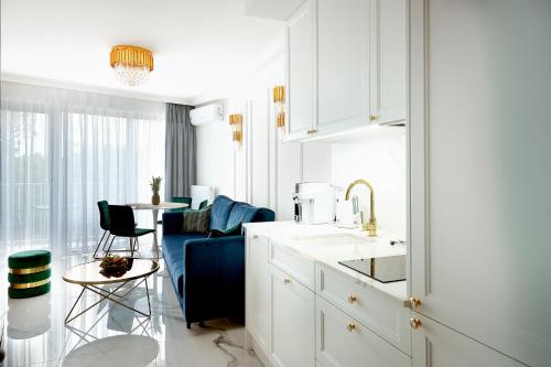 斯维诺乌伊希切Luxury Del Sol Apartments Świnoujście的白色的厨房配有水槽和桌子