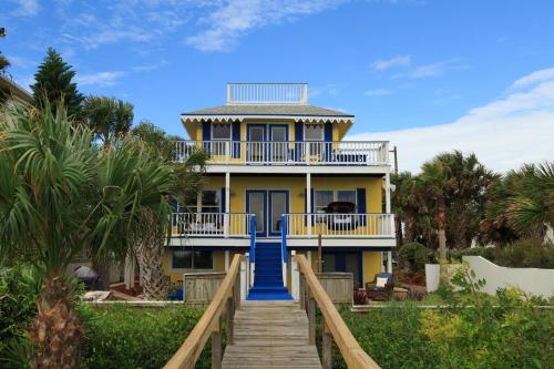 圣奥古斯丁马林楼海湾酒店的黄色的房子,有蓝色的楼梯通往