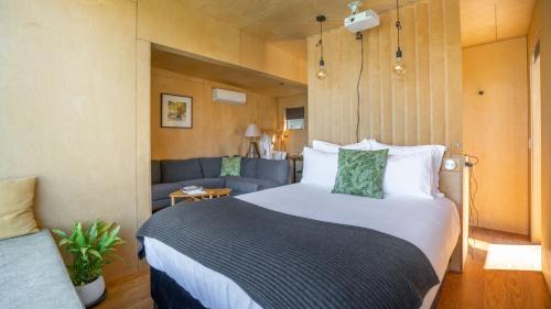 格莱诺基生态风景酒店的一间卧室配有一张大床和一张沙发