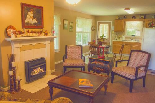 格林维尔Nolichuckey Bluffs Bed & Breakfast Cabins的客厅设有壁炉、桌子和椅子