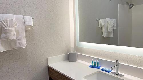 Reidsville里兹维尔智选假日套房酒店 的浴室配有盥洗盆、镜子和毛巾