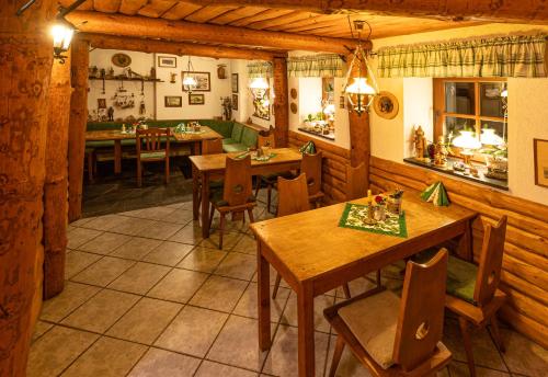 WiesaPension und Gaststätte Zur Knappenschänke的用餐室配有木桌和椅子