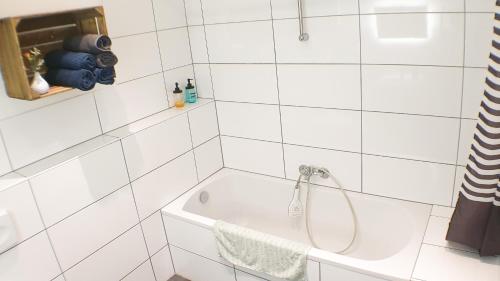科隆Big Appartment near trade fair!的白色瓷砖浴室设有淋浴和浴缸。