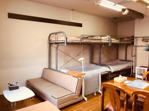 京都Nishijin IVY 5 persons room的客房设有两张双层床和一张桌子。